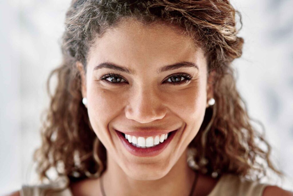Mulher sorridente após limpeza dentária na clínica dentária Lagoa